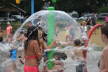 kids running around water splash pad